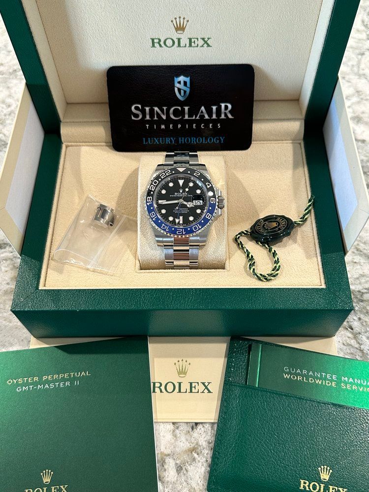A rolex watch in a box with a sinclair card