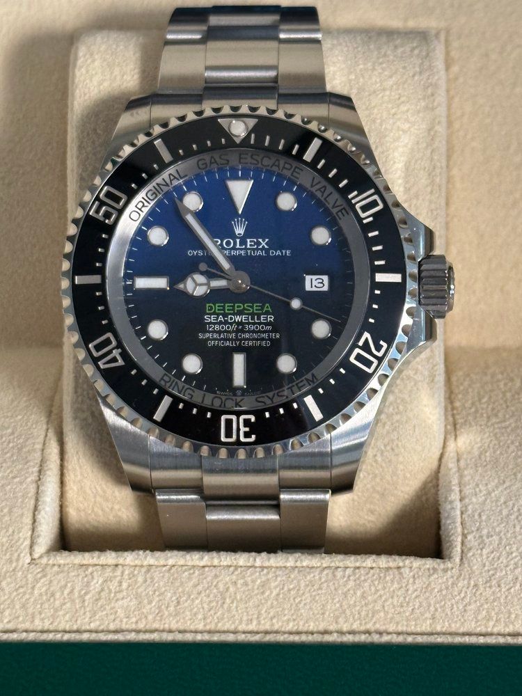 A silver rolex watch with a blue face