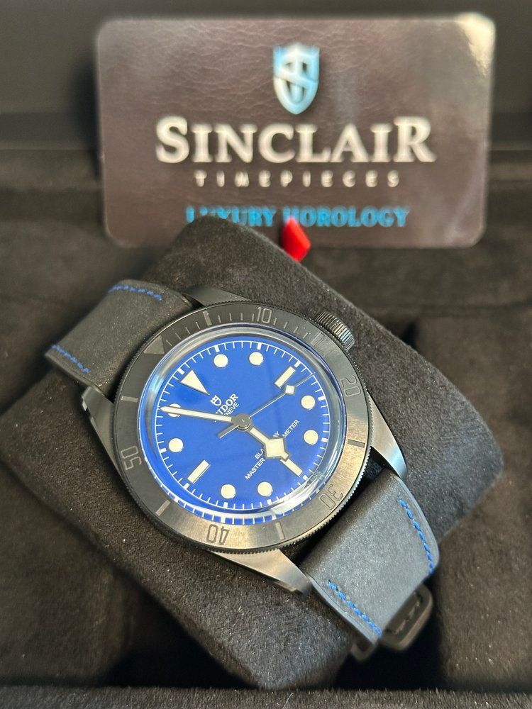 A sinclair watch sits in a black case
