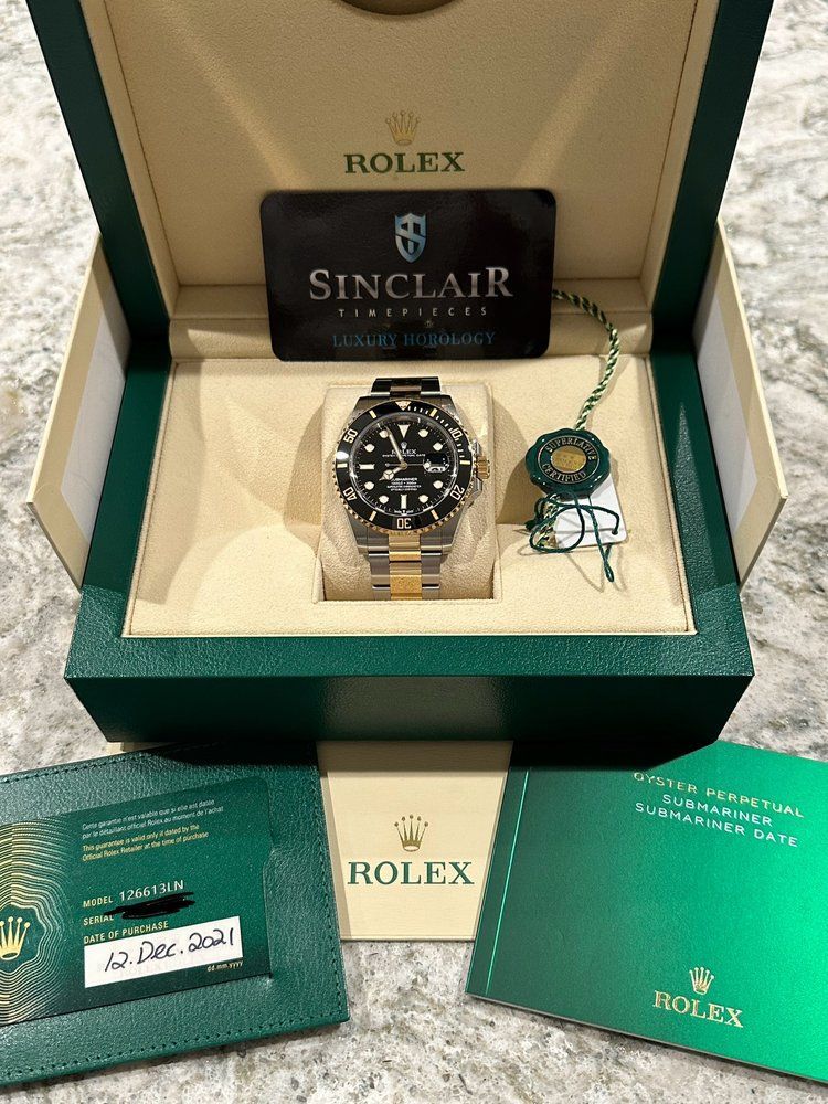 A rolex watch is in a box with a certificate