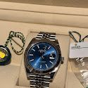 A rolex watch is sitting on top of a display case.