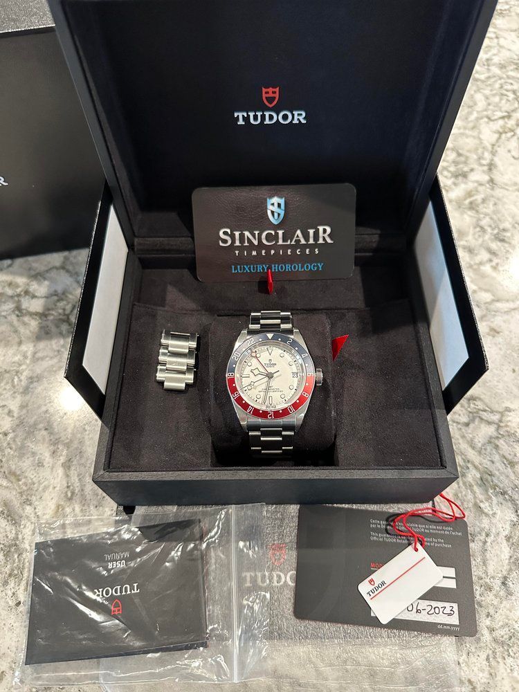 A tudor watch is sitting inside of a black box.
