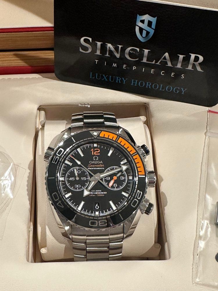 A watch in a box that says sinclair on it