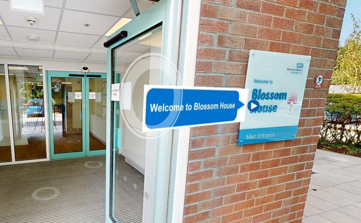 An aerial view of a large building with a play button in the middle.