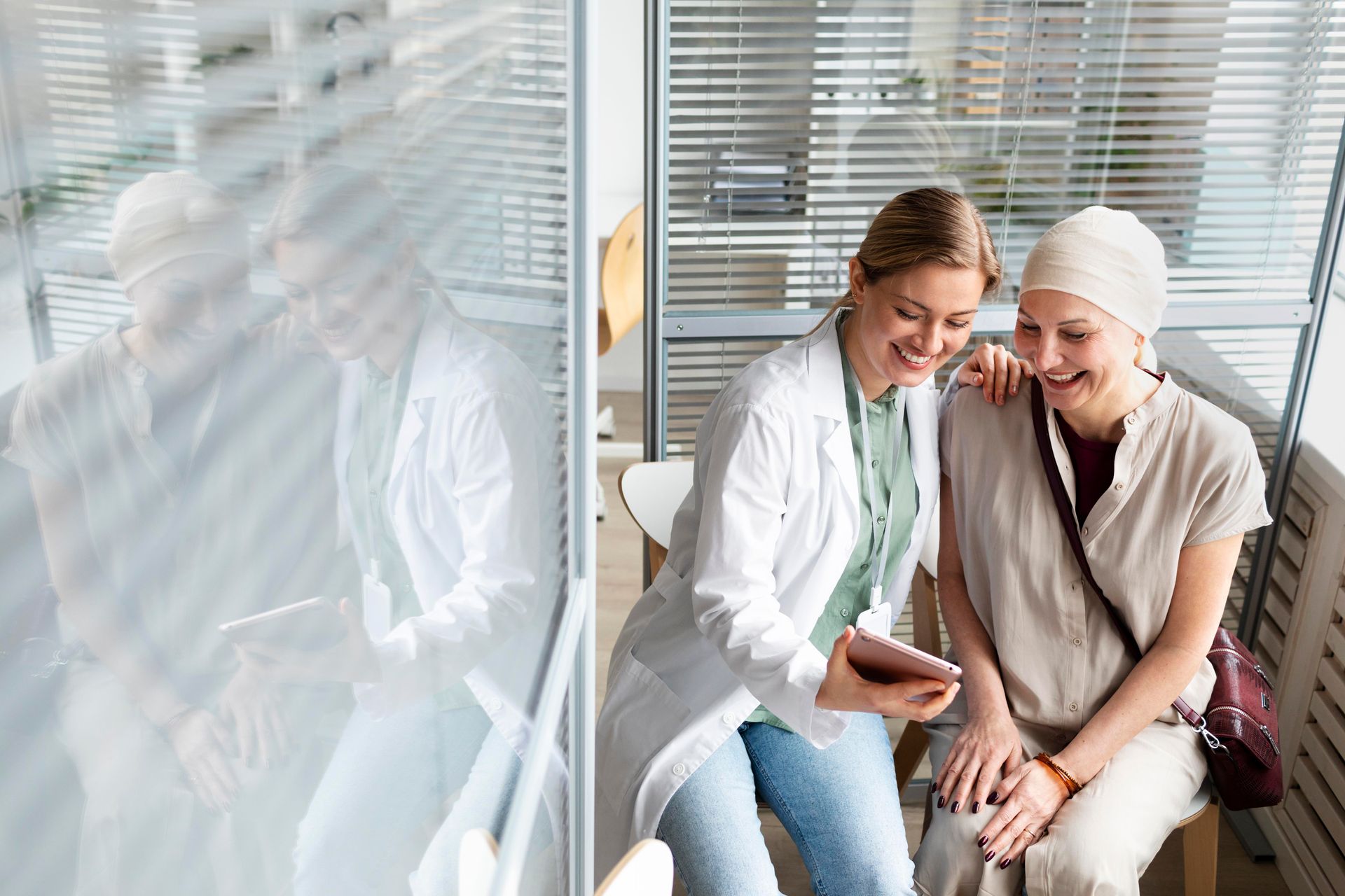A doctor is talking to a patient with cancer while looking at a tablet.