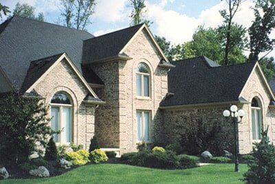 Stone House With Dark Gray Roof — Landscaping in Shelby Township, MI