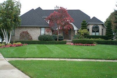 Elegant House With Large Front Yard And Dark Gray Roof — Landscaping in Shelby Township, MI