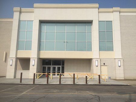 A large building with a lot of windows and a parking lot in front of it