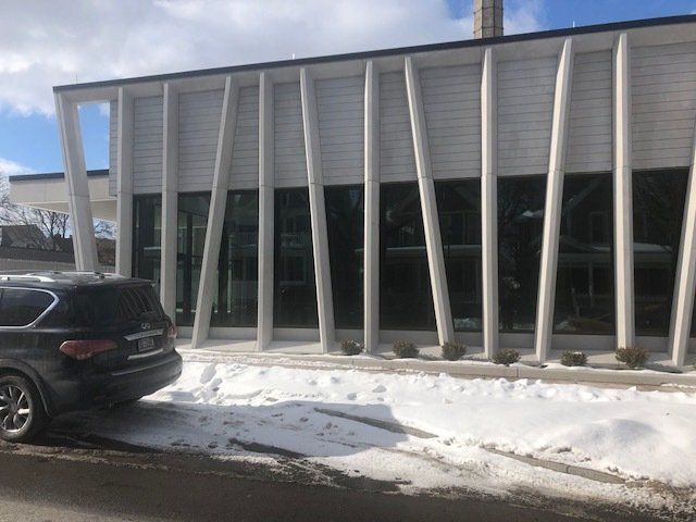 A car is parked in front of a building in the snow