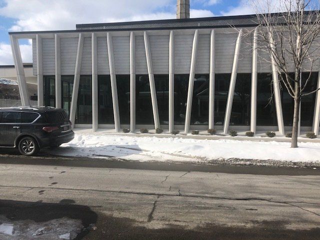 A black suv is parked in front of a building
