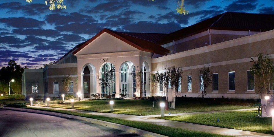 A large building with a red roof is lit up at night
