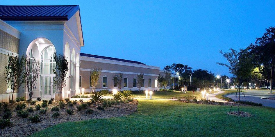A large building with a lot of windows is lit up at night