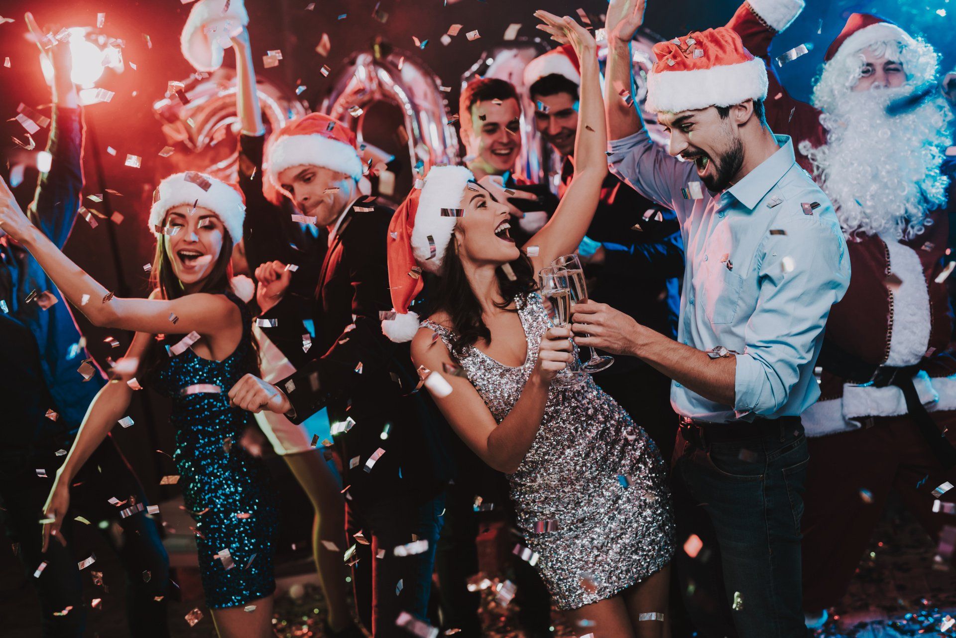 People dancing and drinking at a Christmas party.