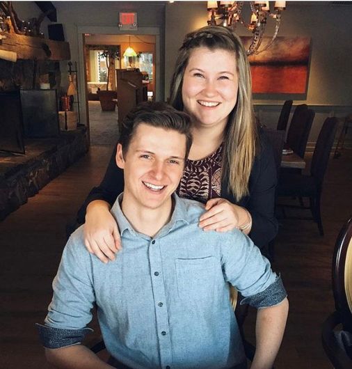 A man and a woman are posing for a picture in a restaurant