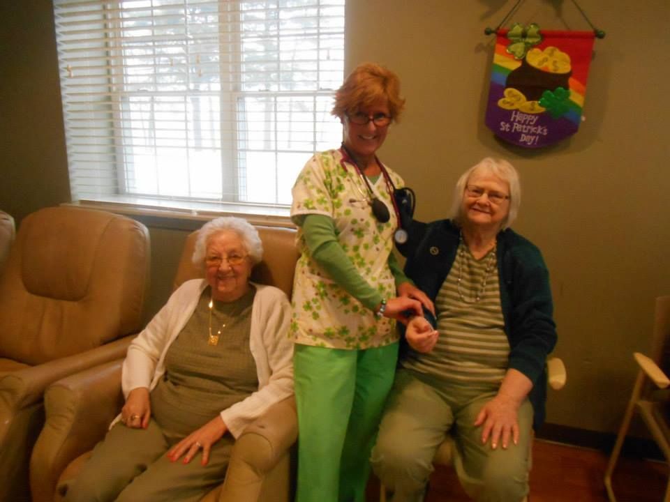 A nurse is examining an elderly woman with a stethoscope.