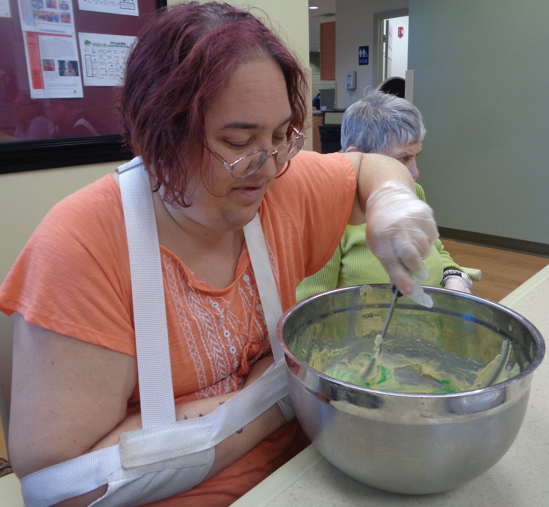 A woman with a cast on her arm is mixing something in a bowl