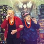Two older women are posing for a picture in front of a large balloon.