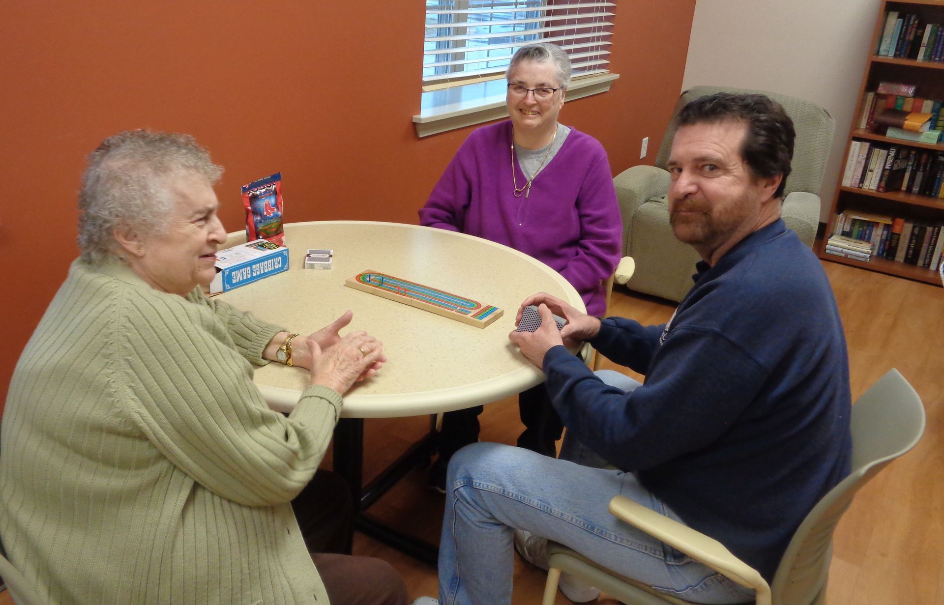 A group of people are sitting around a table playing a board game