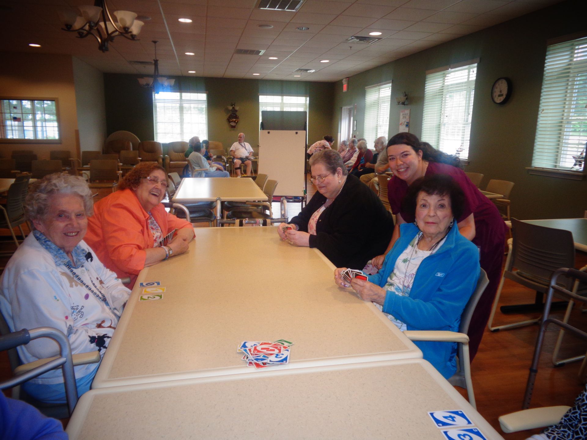 A group of elderly women are sitting around a table