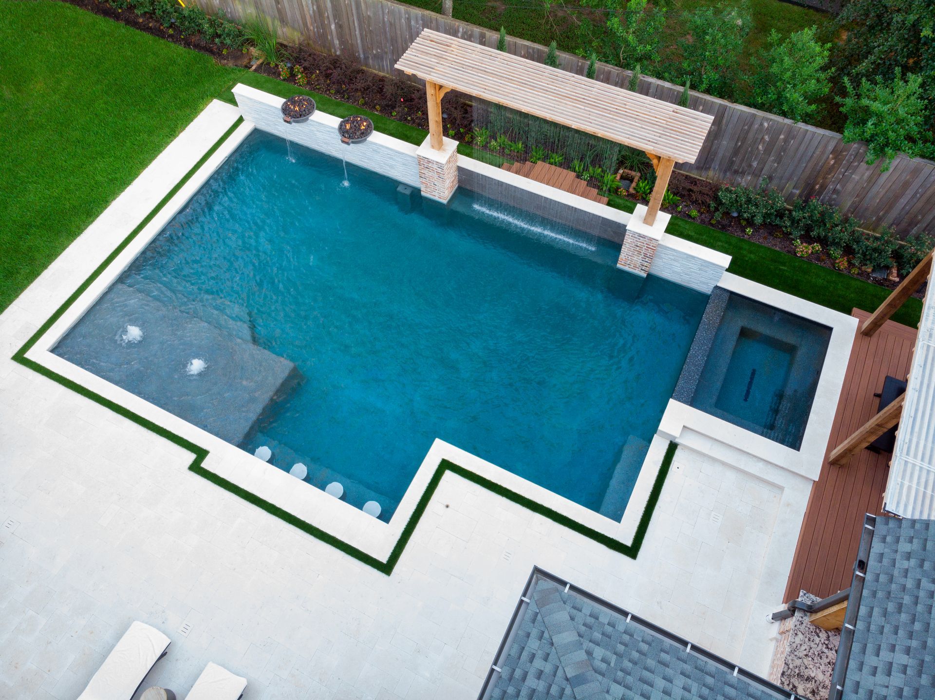 Modern backyard pool with built-in seating and lounge chairs at sunset