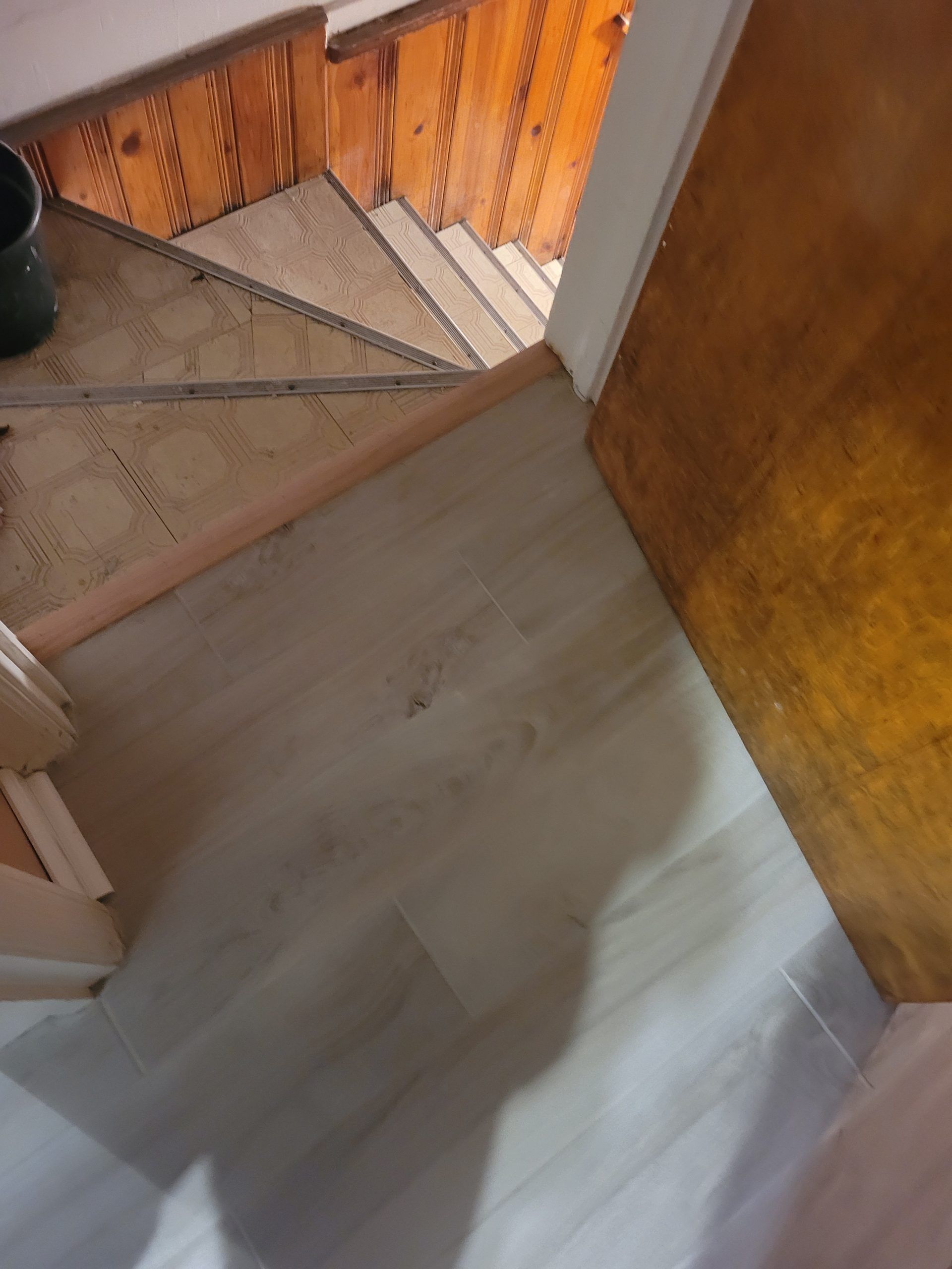 Wooden staircase with light wood flooring and doorway on the right.