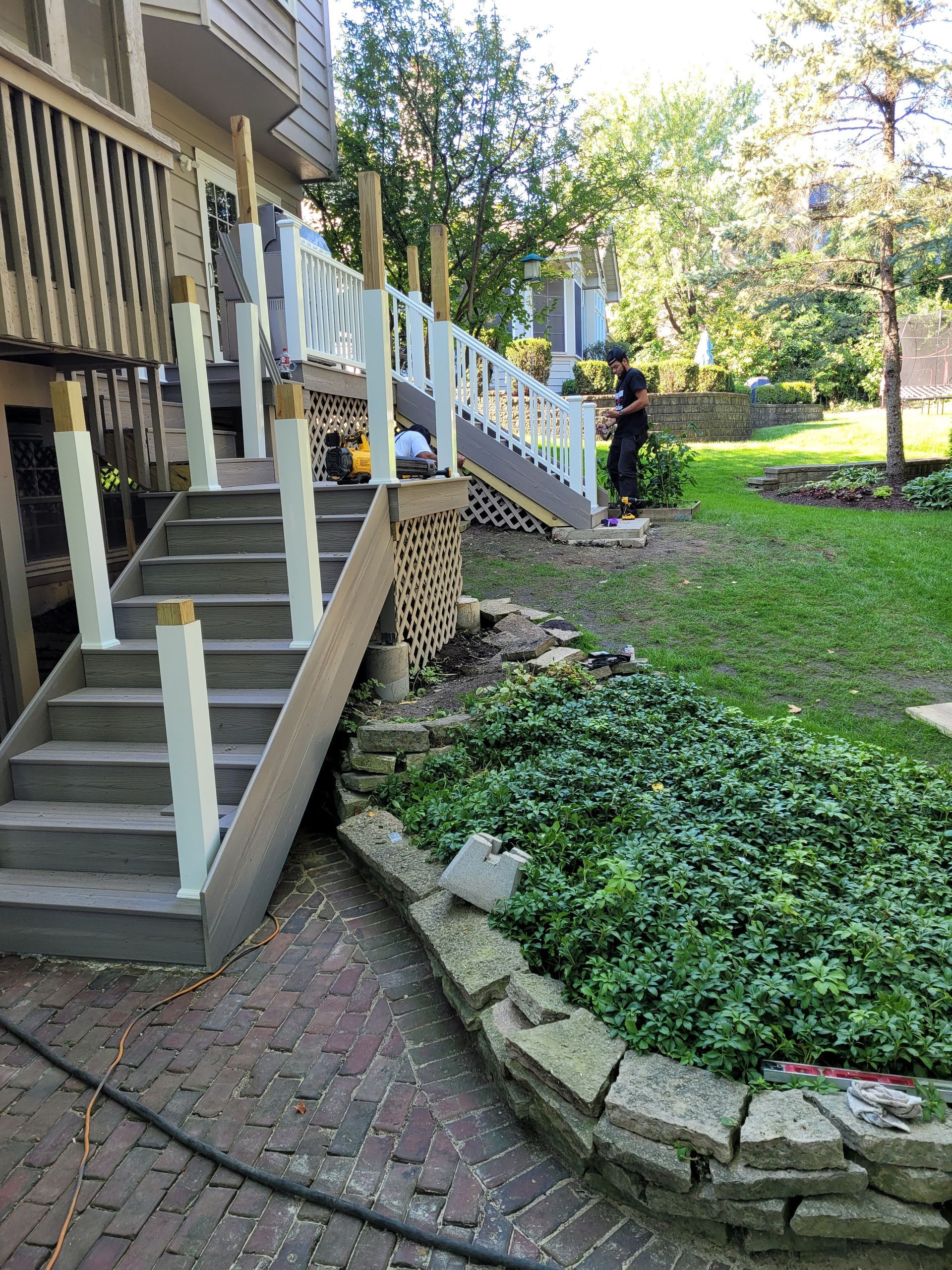 Wooden steps leading to a beige door, set against a brick and stone facade.