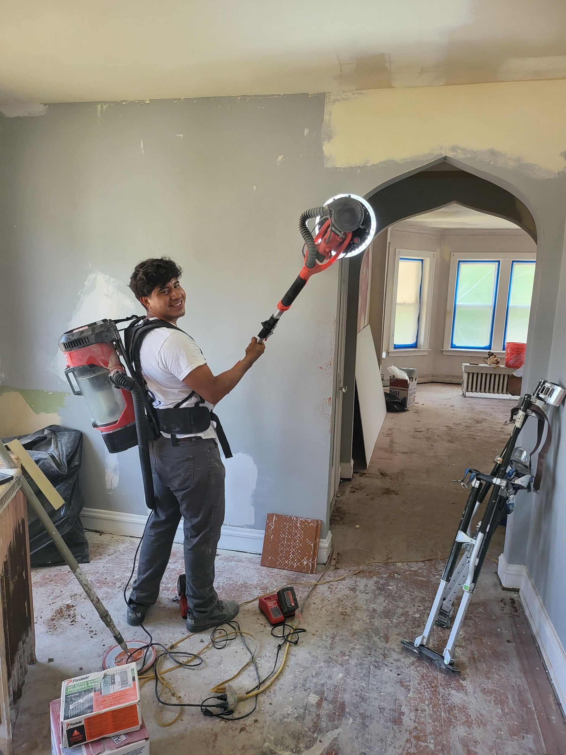 A doorway in a room with black brick walls and a white door leading to a bathroom.