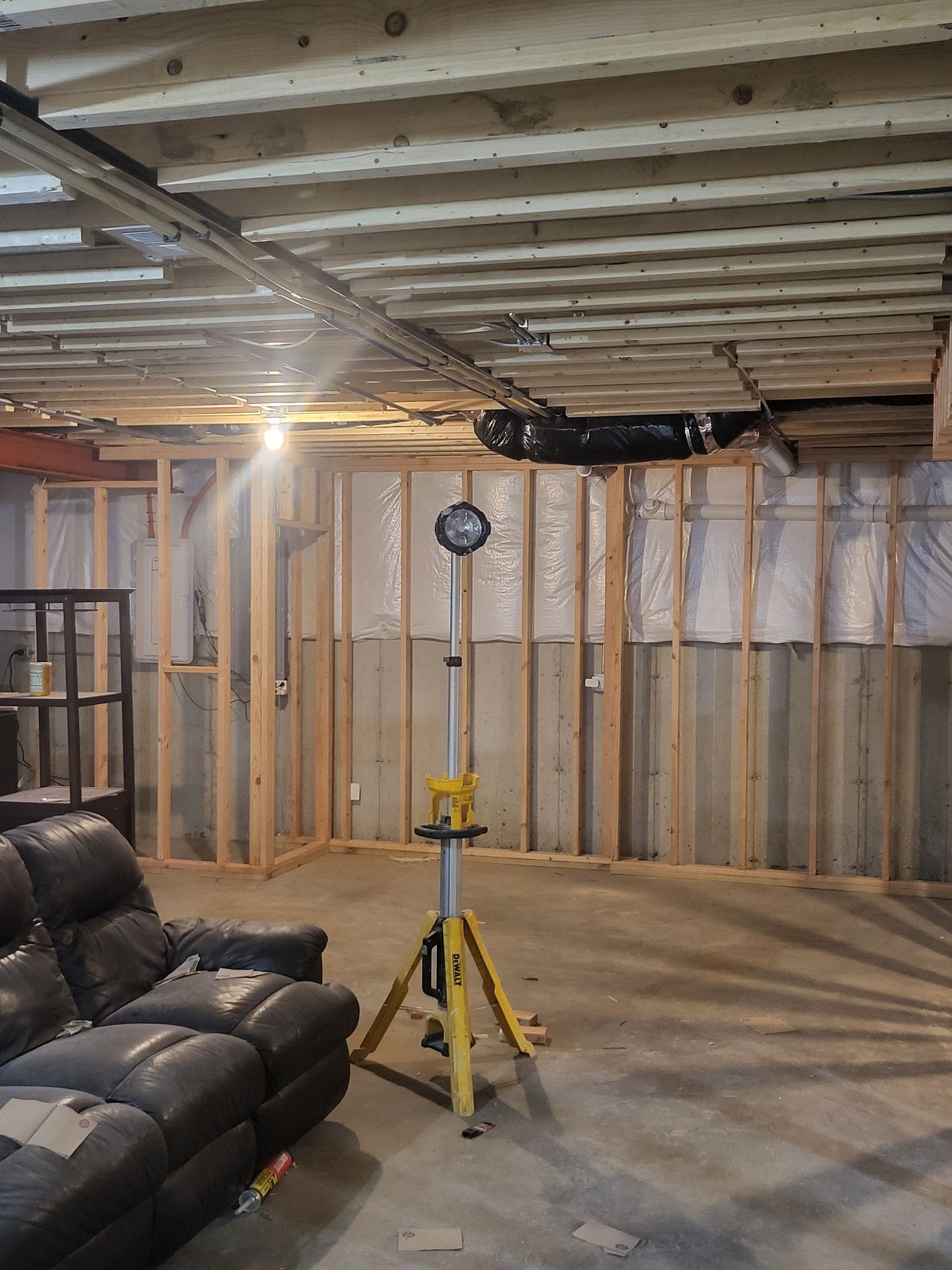 Empty room with light wood floors, window, door, and staircase, painted in cool tones.