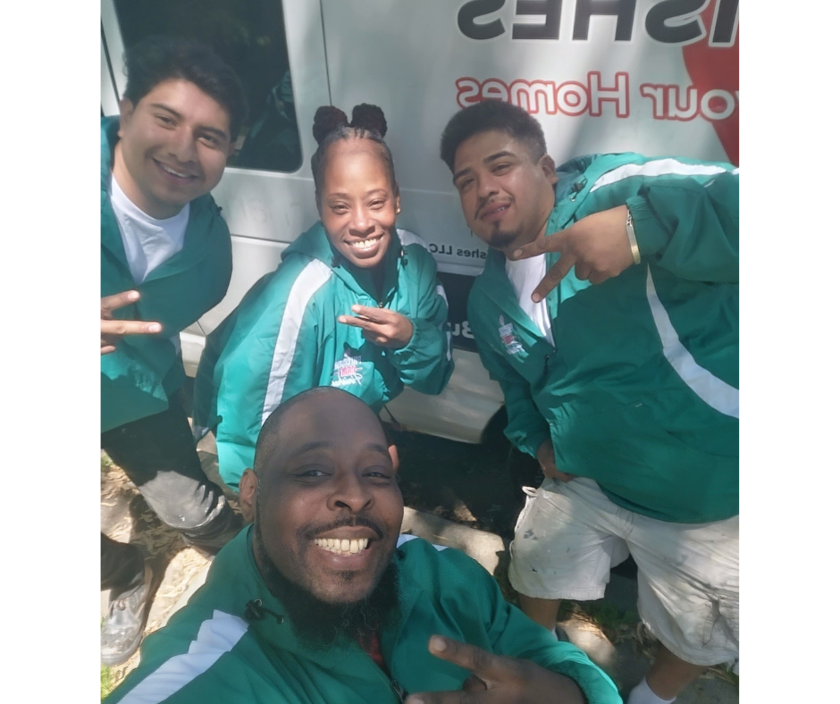 Two workers drywalling an interior room. One applies compound to the wall, 