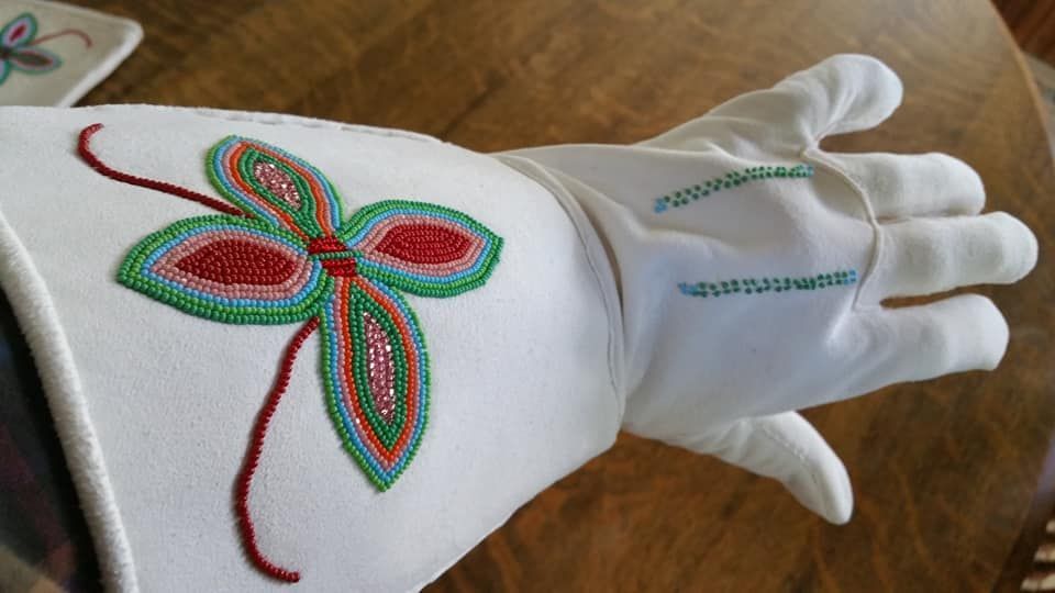 A white glove with a flower embroidered on it