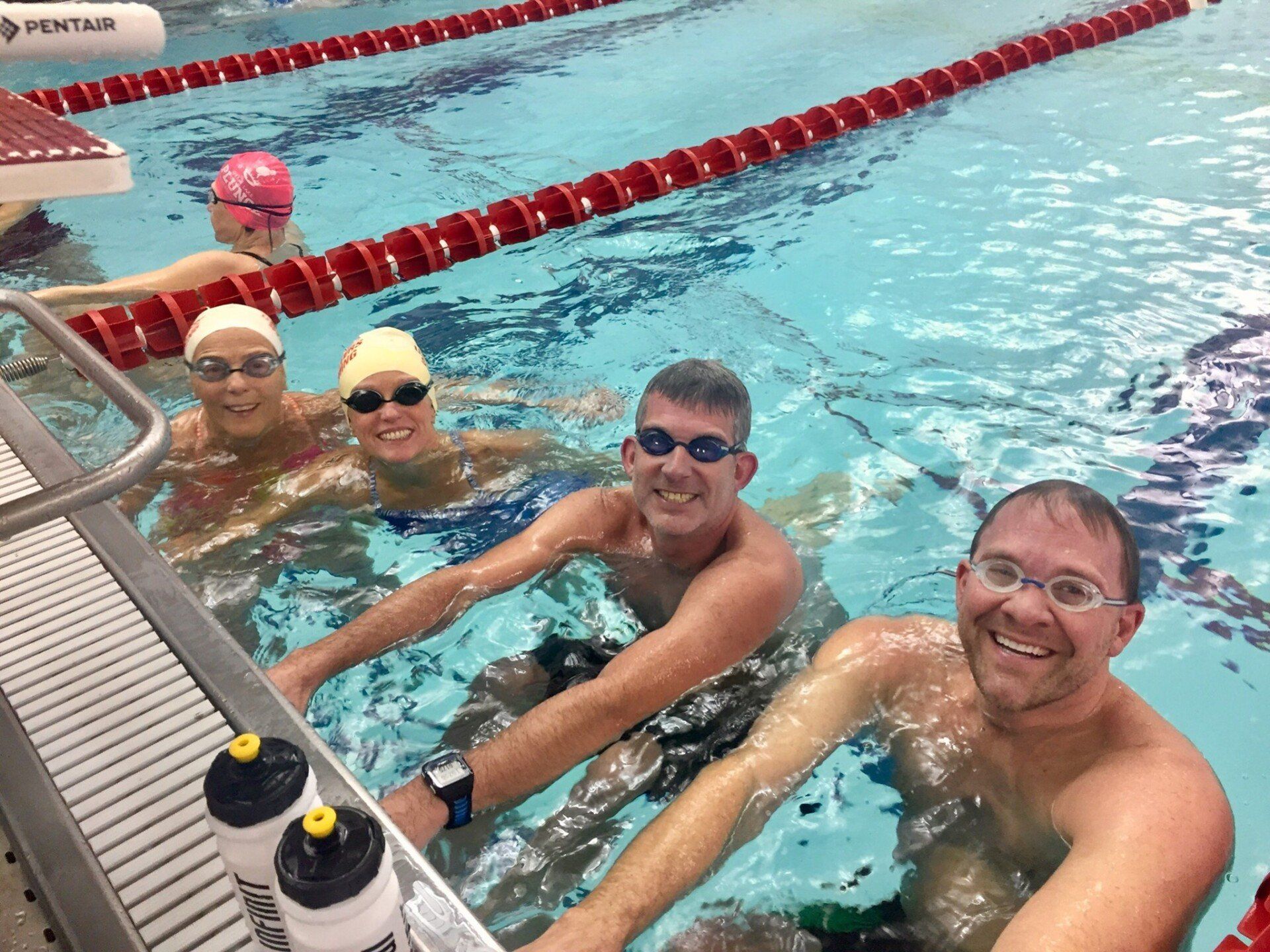 A group of people are swimming in a pool.