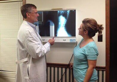 Doctor showing X-ray to a patient - back pain in Saraland, AL