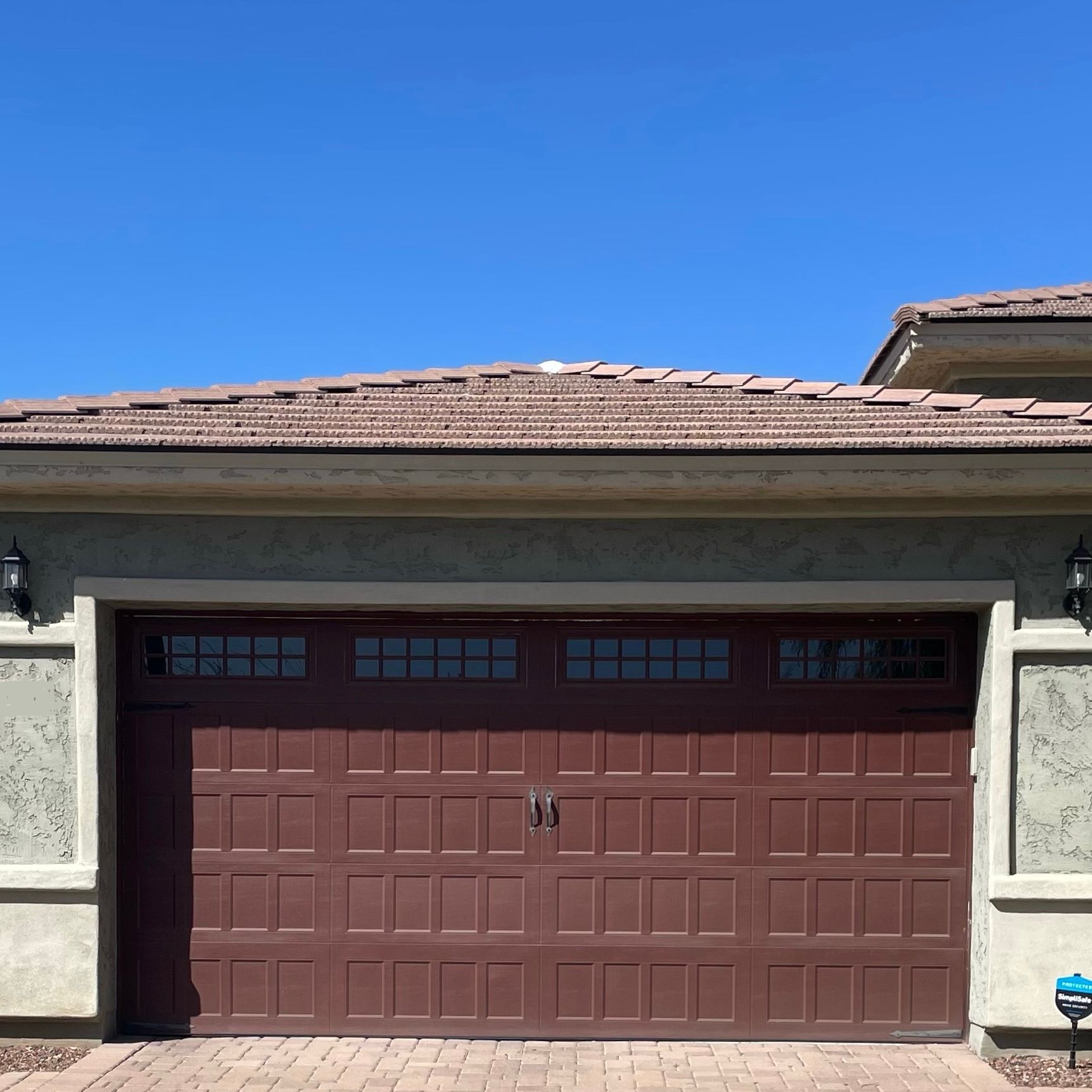 A large brown garage door is on the side of a house