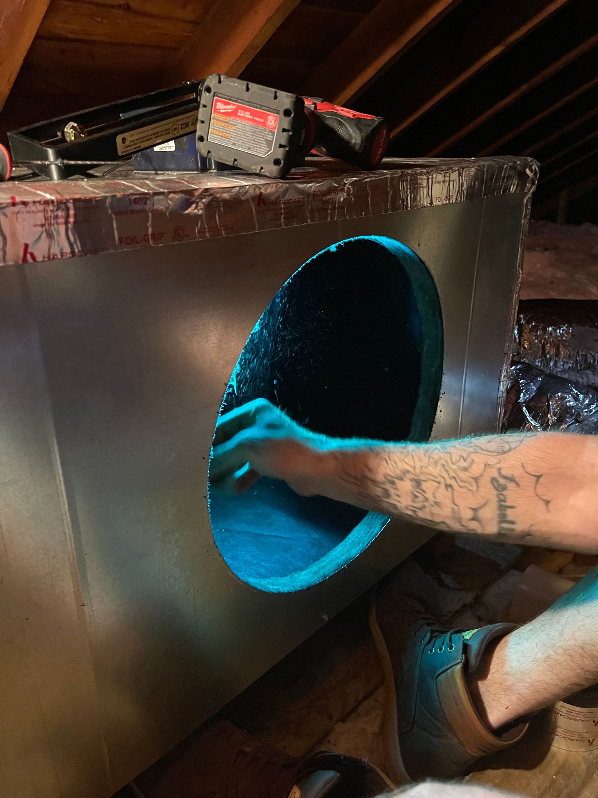 Hands reaching into a glowing blue circular opening in a black box-like structure