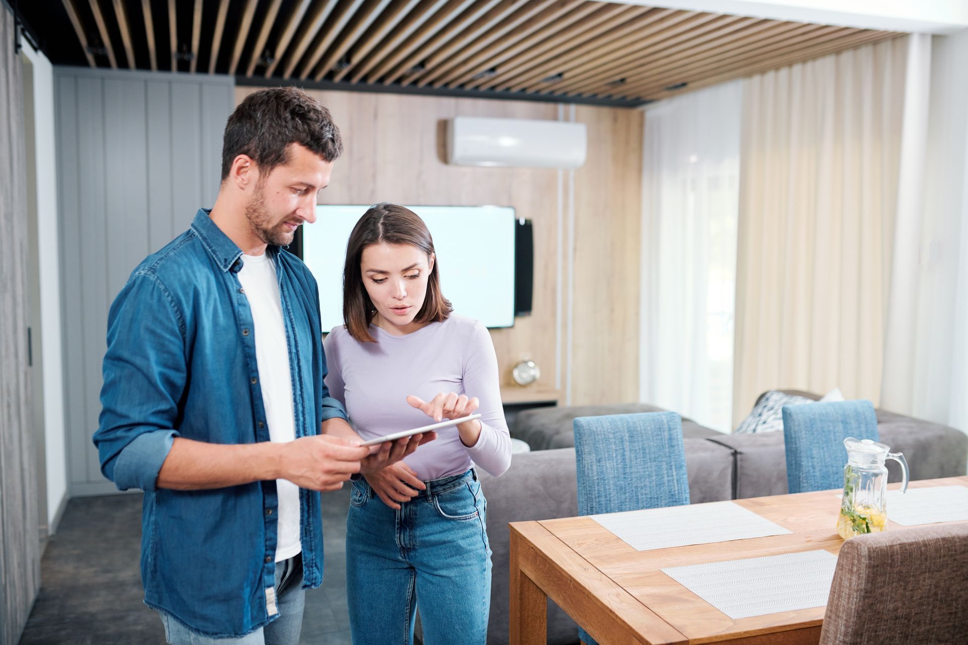 Two people reviewing paperwork in a modern apartment dining area