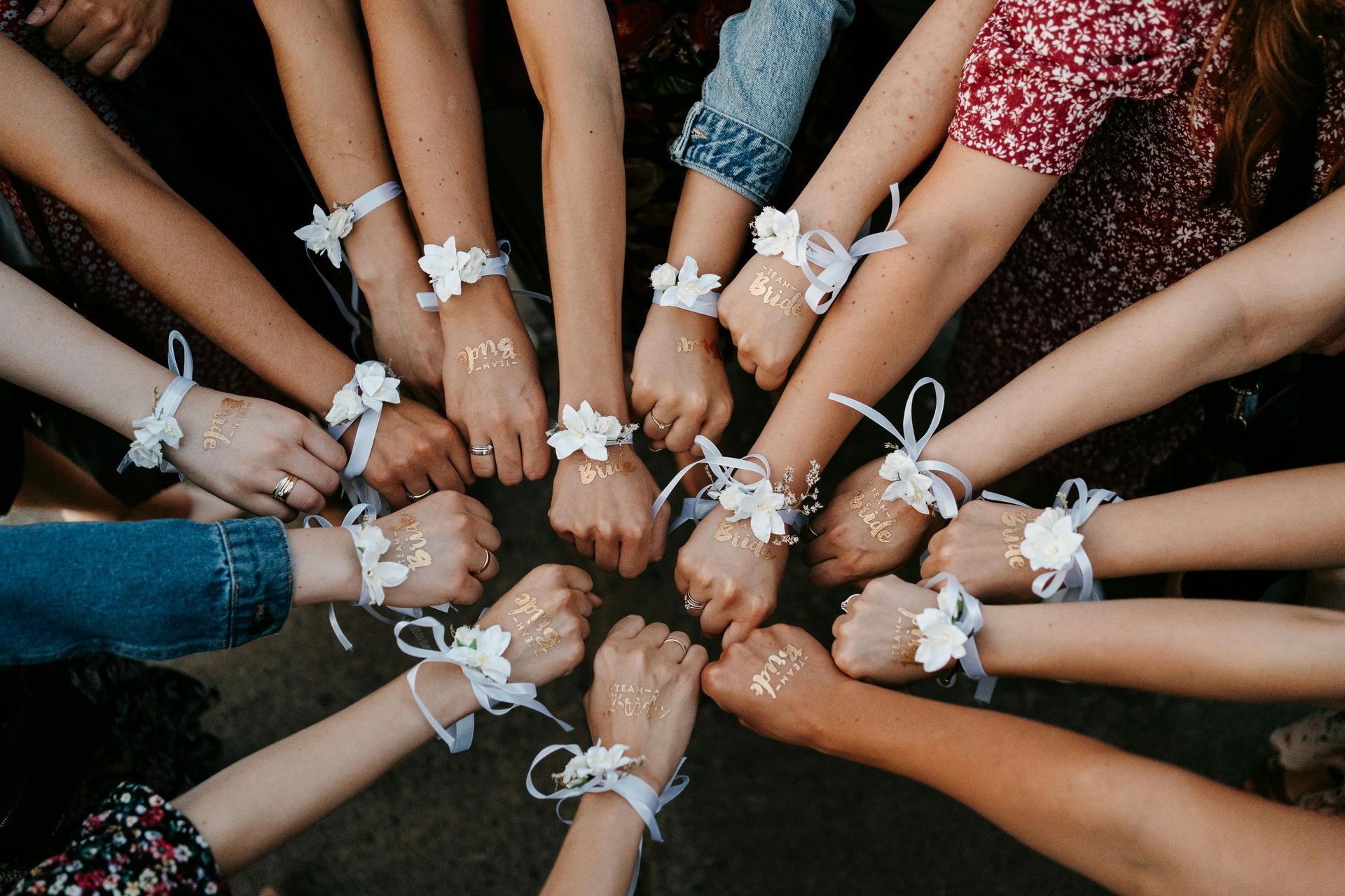 A group of women are sitting in a circle with their hands tied together.