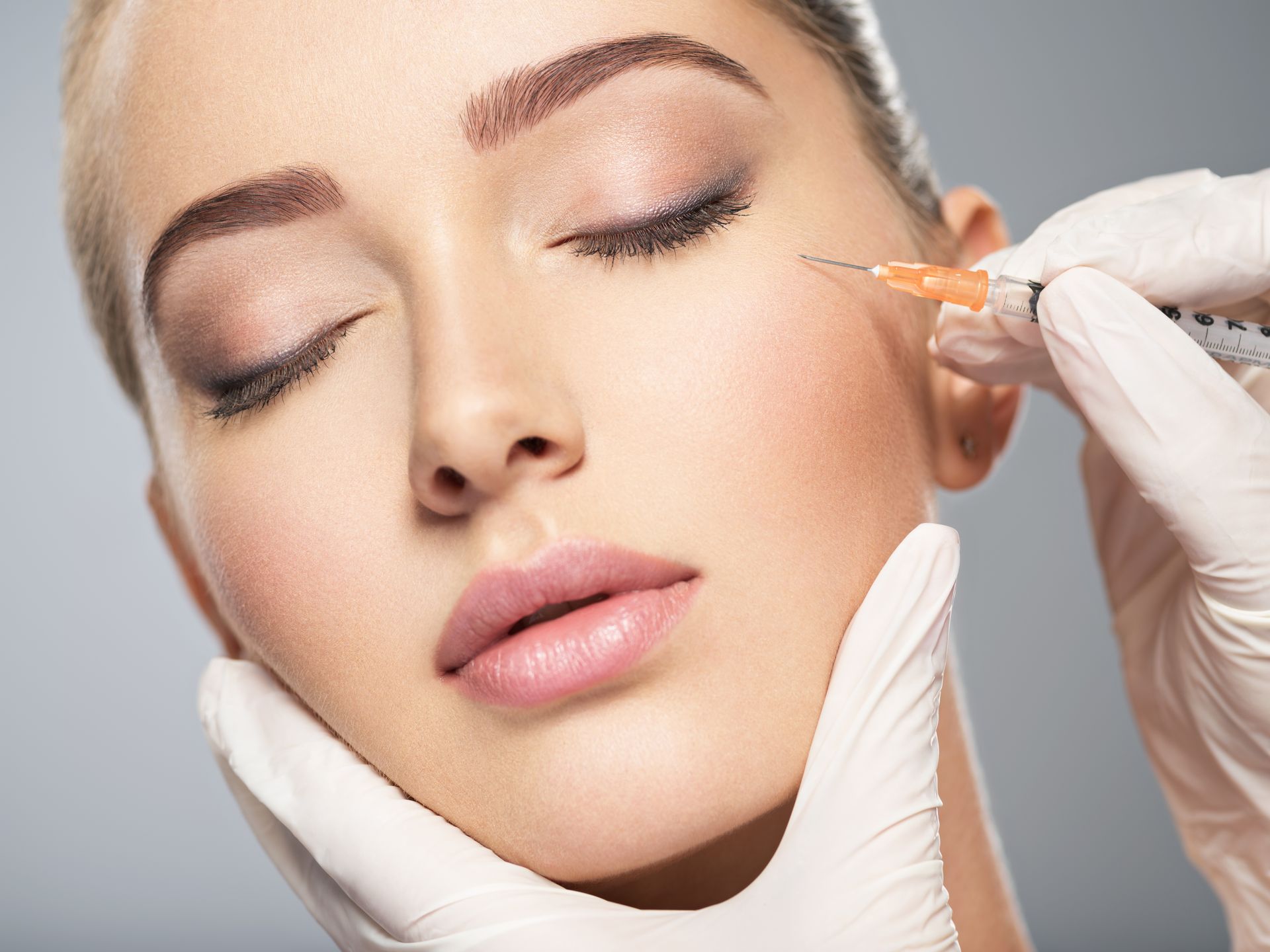 A woman is getting a botox injection in her face.