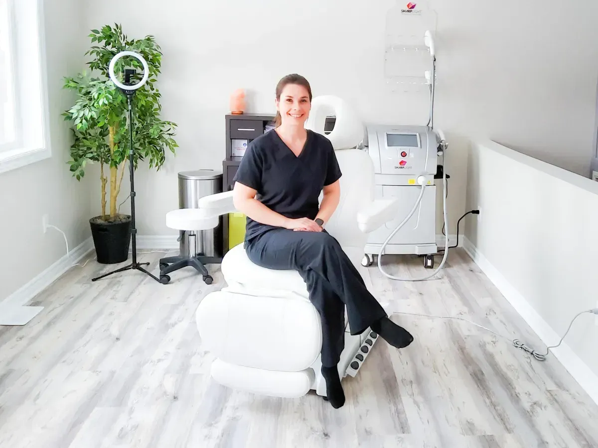 A woman is sitting on a white chair in a room.