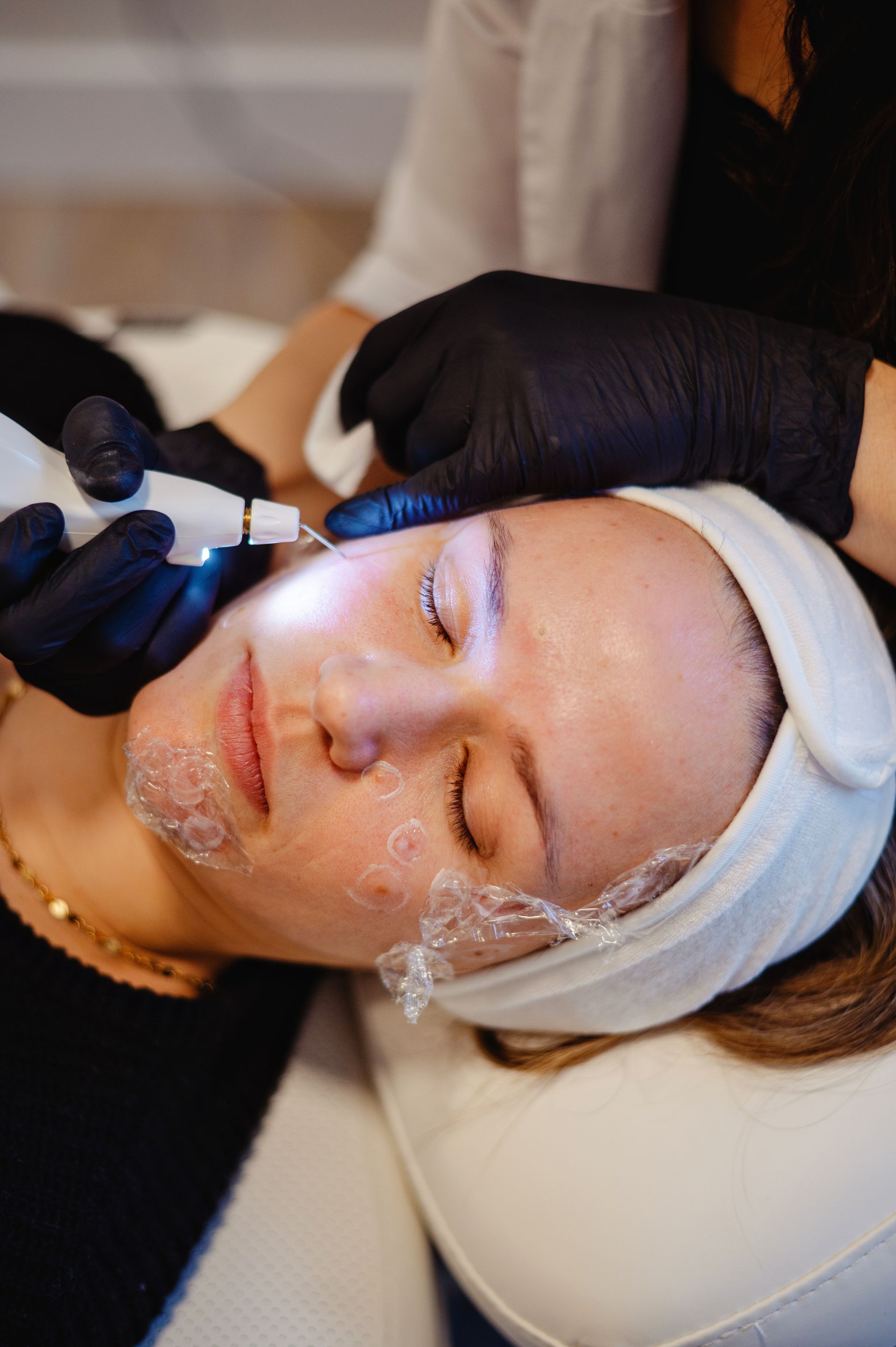 A woman is getting her face examined by a doctor.