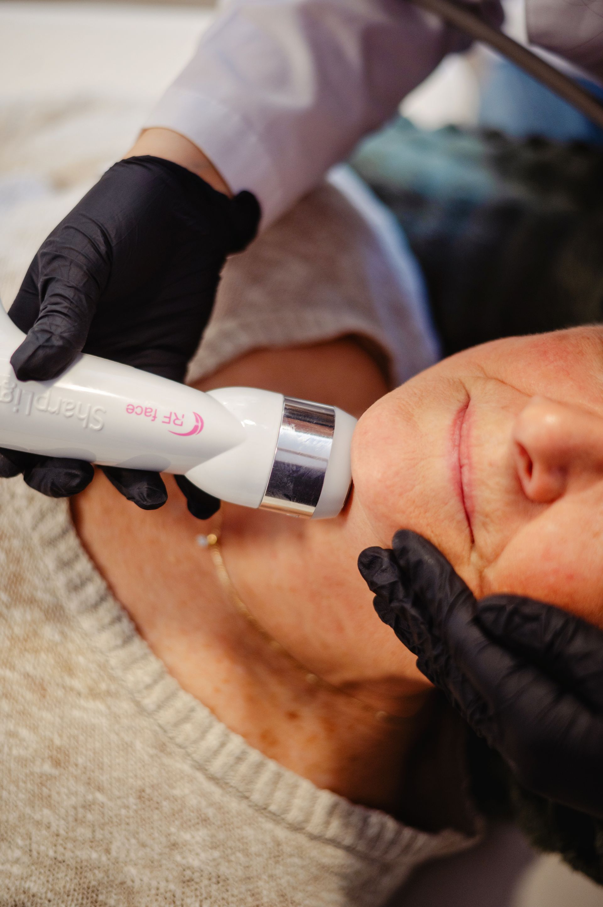 A woman in a sports bra and shorts is standing in front of a white wall.