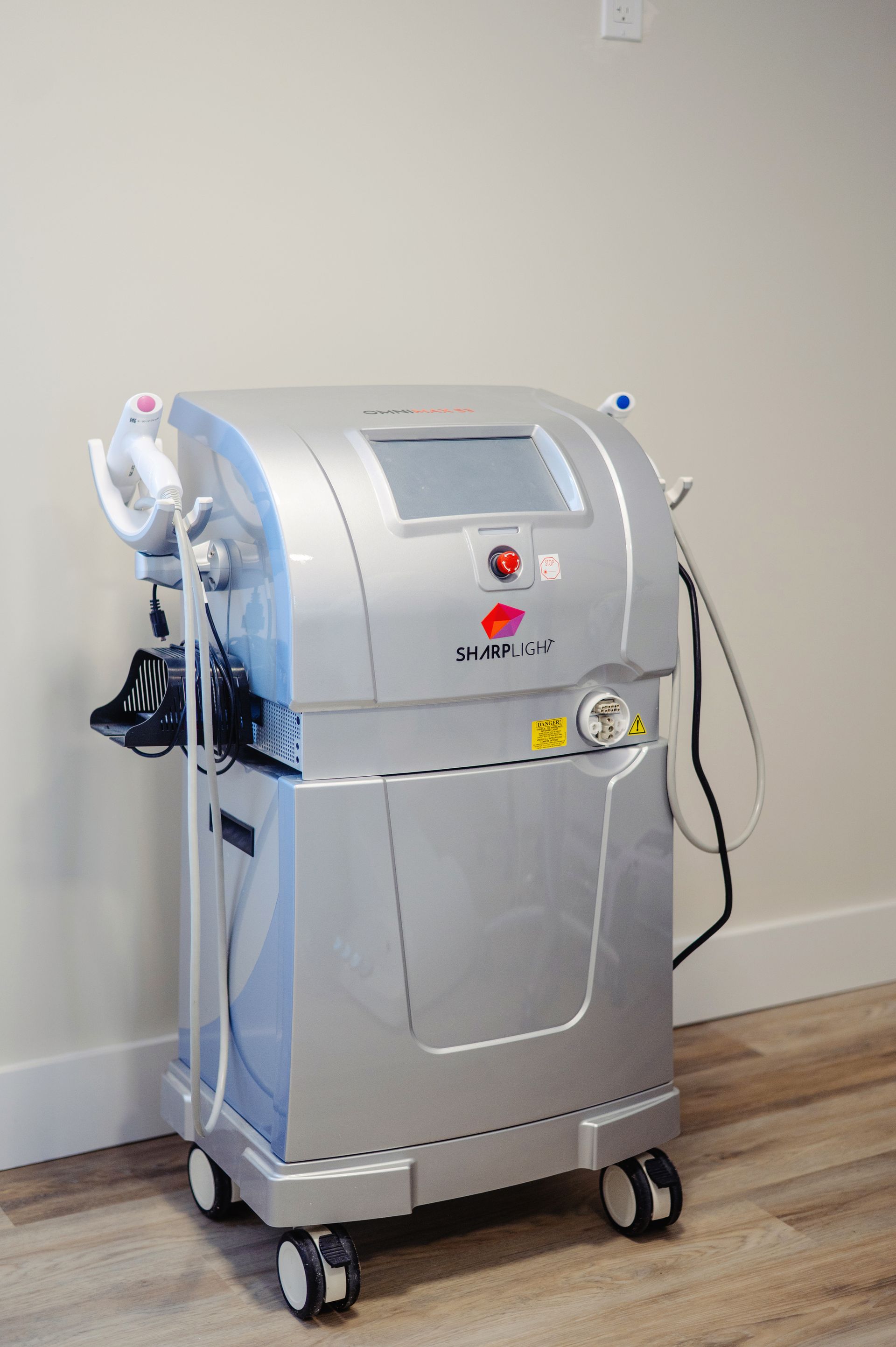 A woman in a white tank top is touching her shoulder.