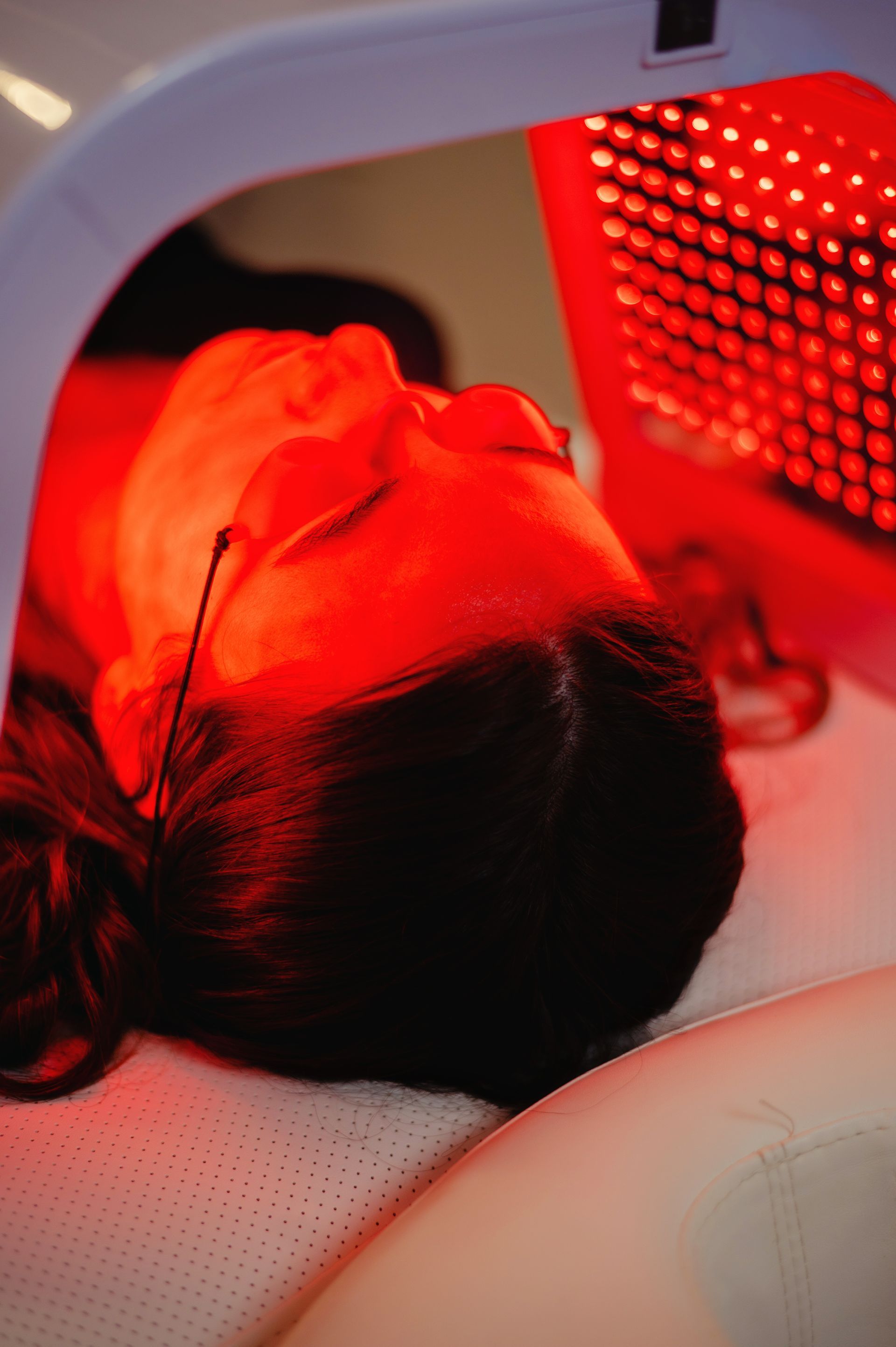 A woman is sitting at a table with her hand on her face.