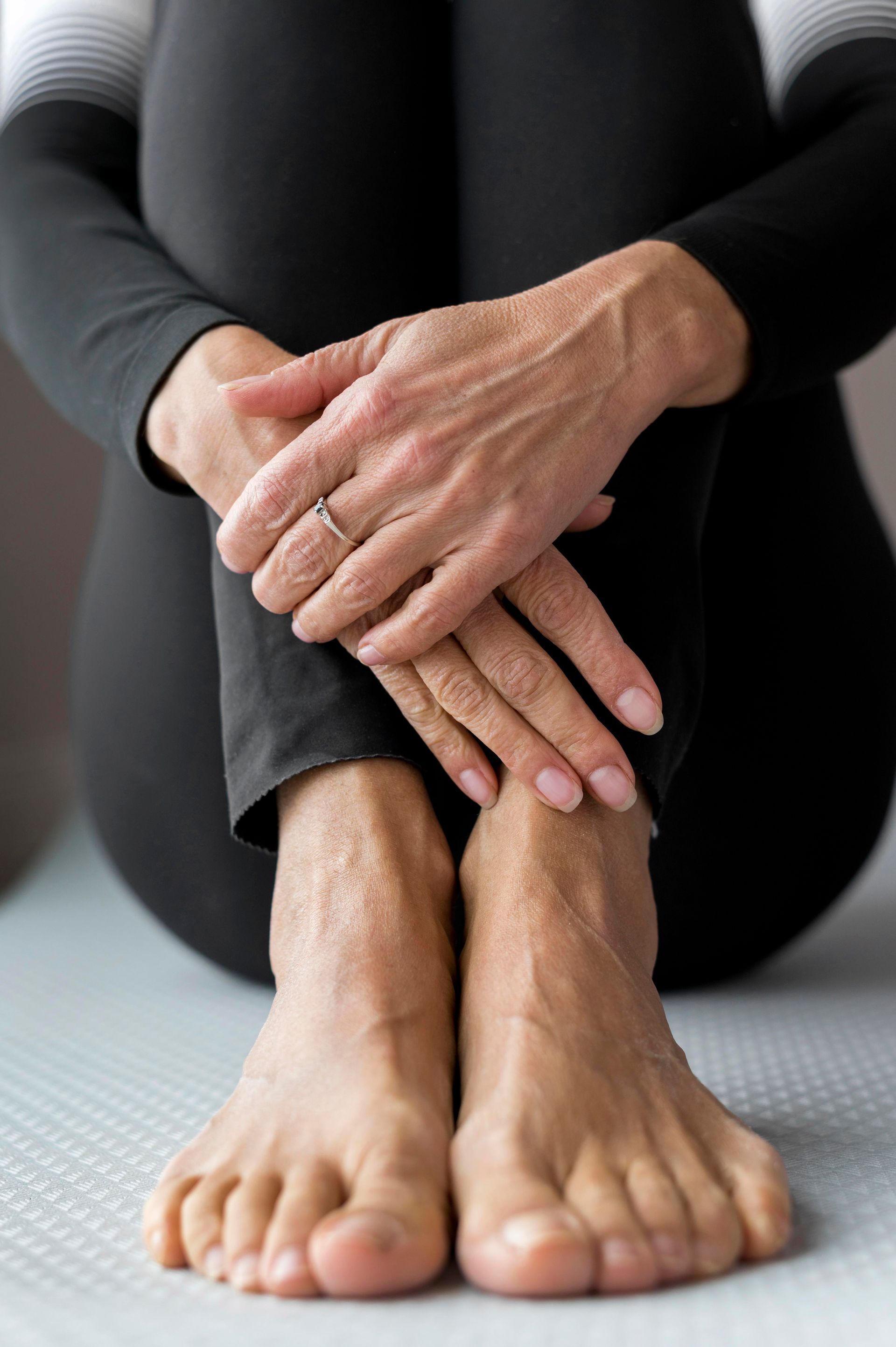 A woman is touching her foot on a leaf.