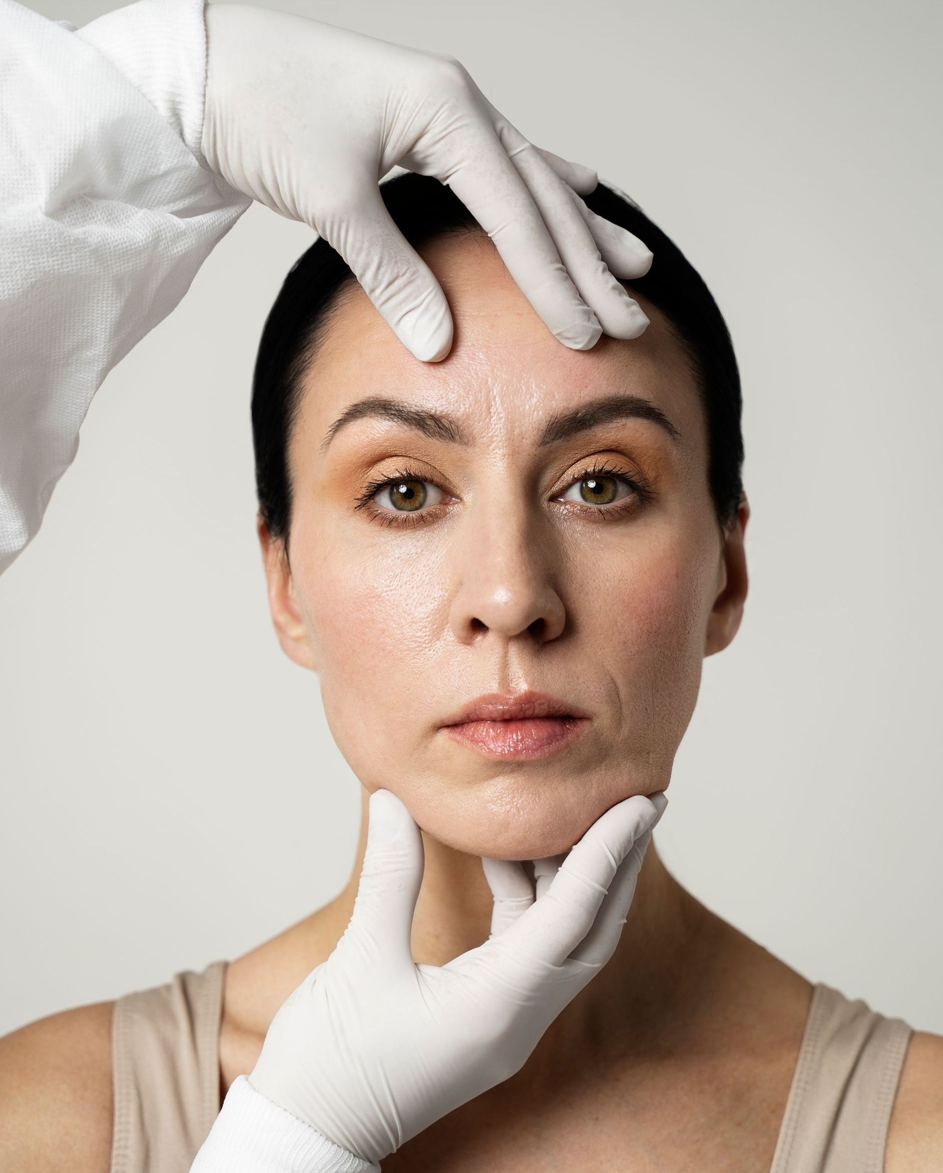 A woman is getting her face examined by a doctor.