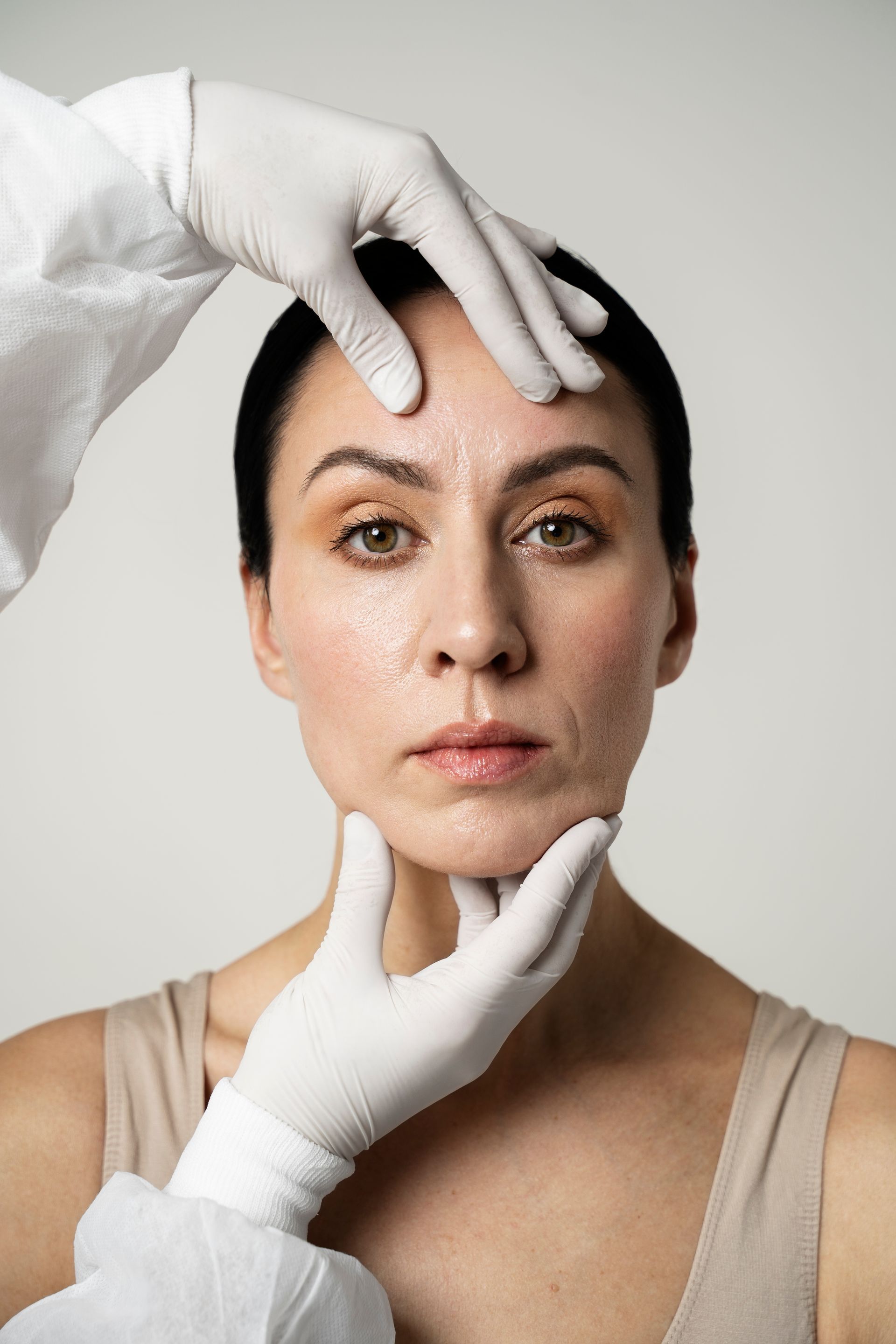 A woman is getting her face examined by a doctor.