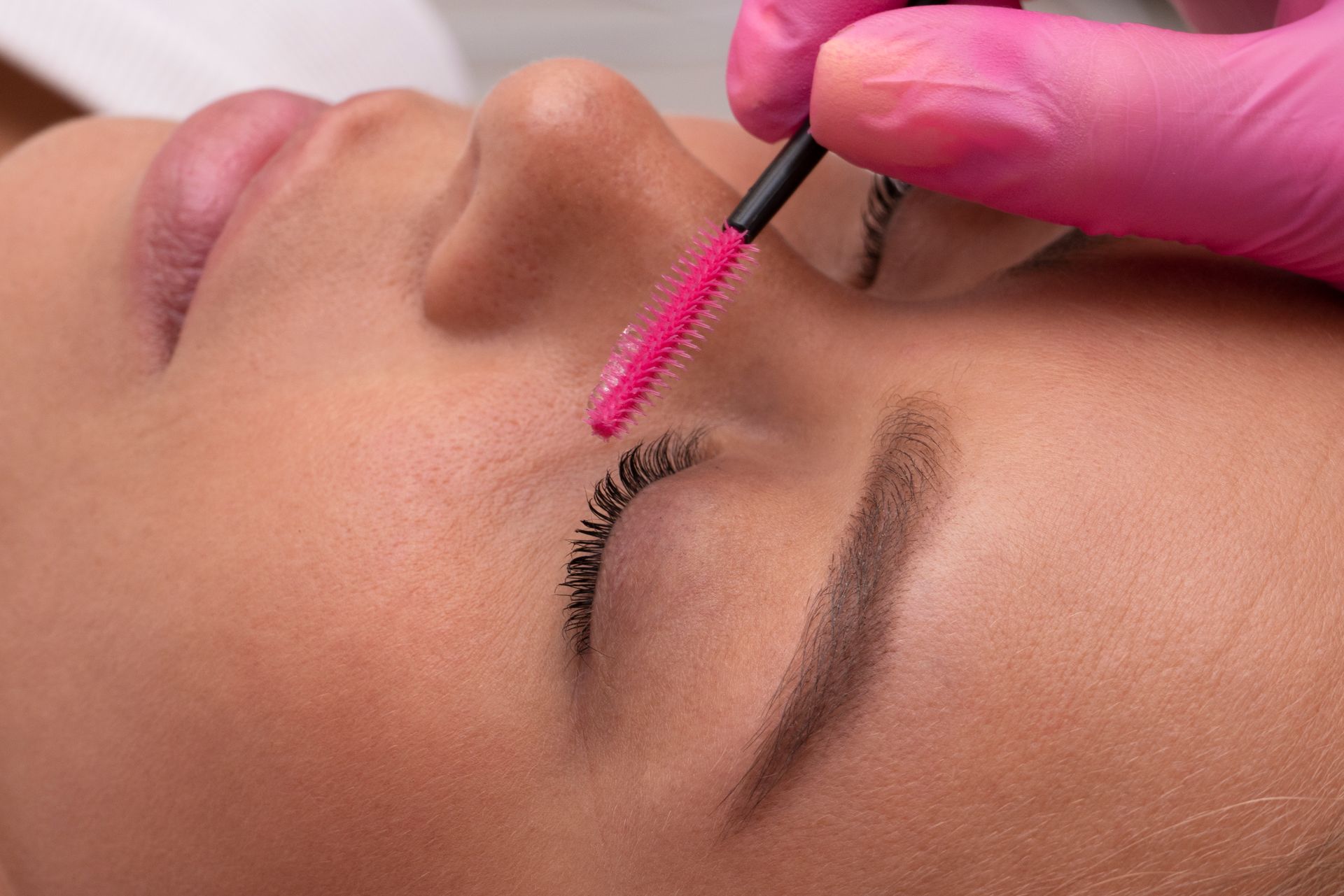 A woman is getting her eyelashes done at a beauty salon.