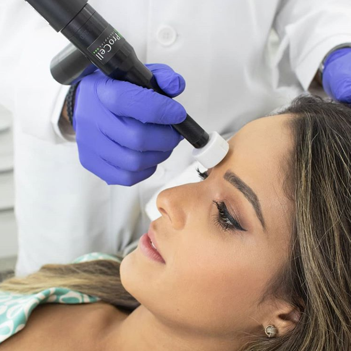 A woman is getting a laser treatment on her face