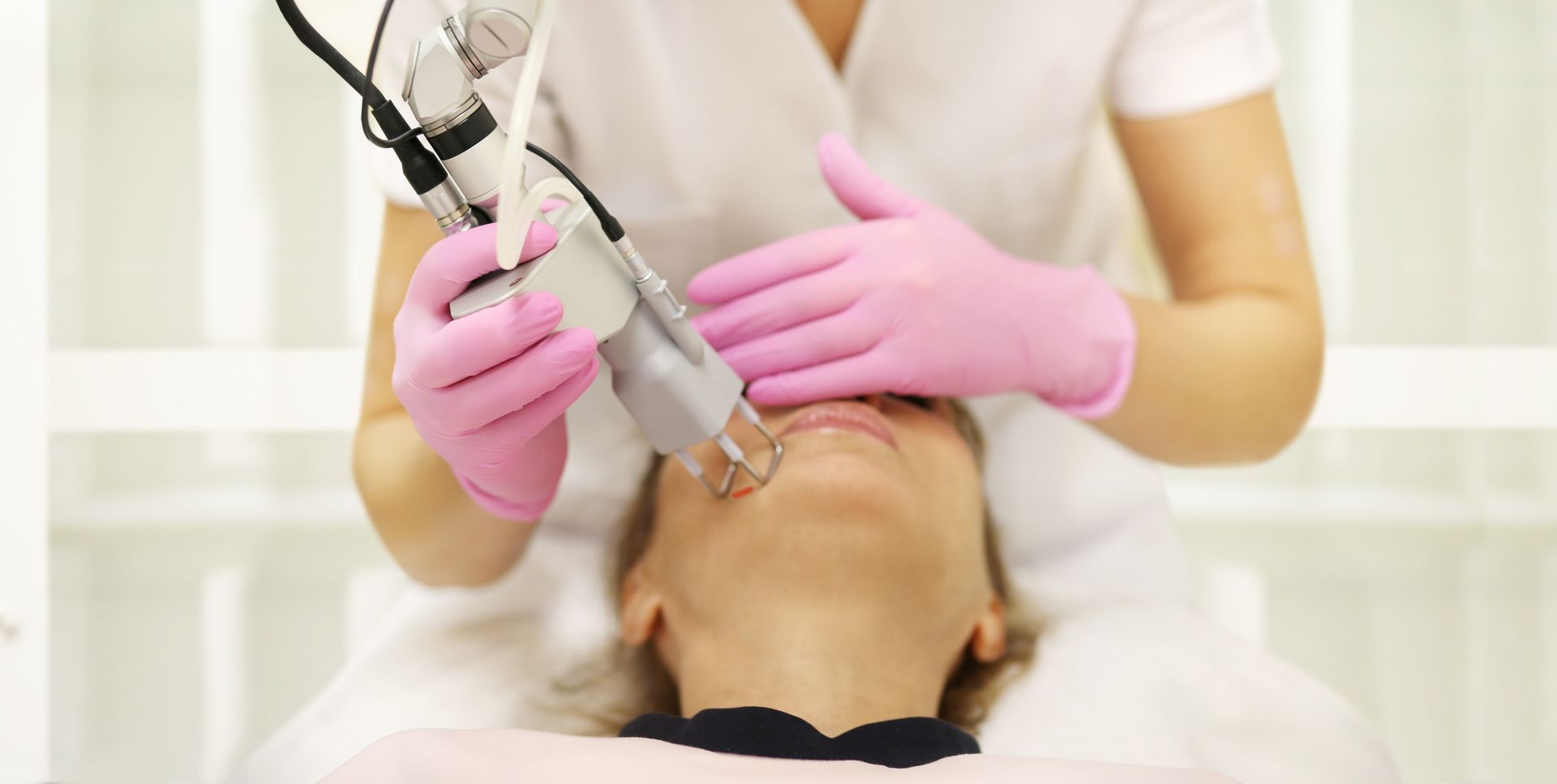 A woman is getting a laser treatment on her face.