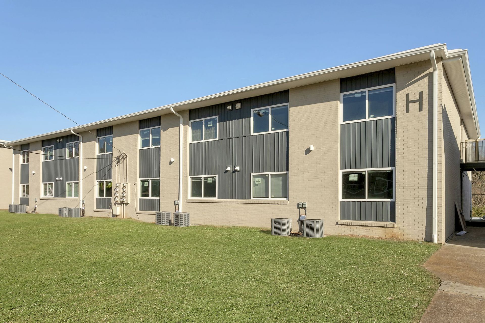 A tan two-story apartment building labeled 