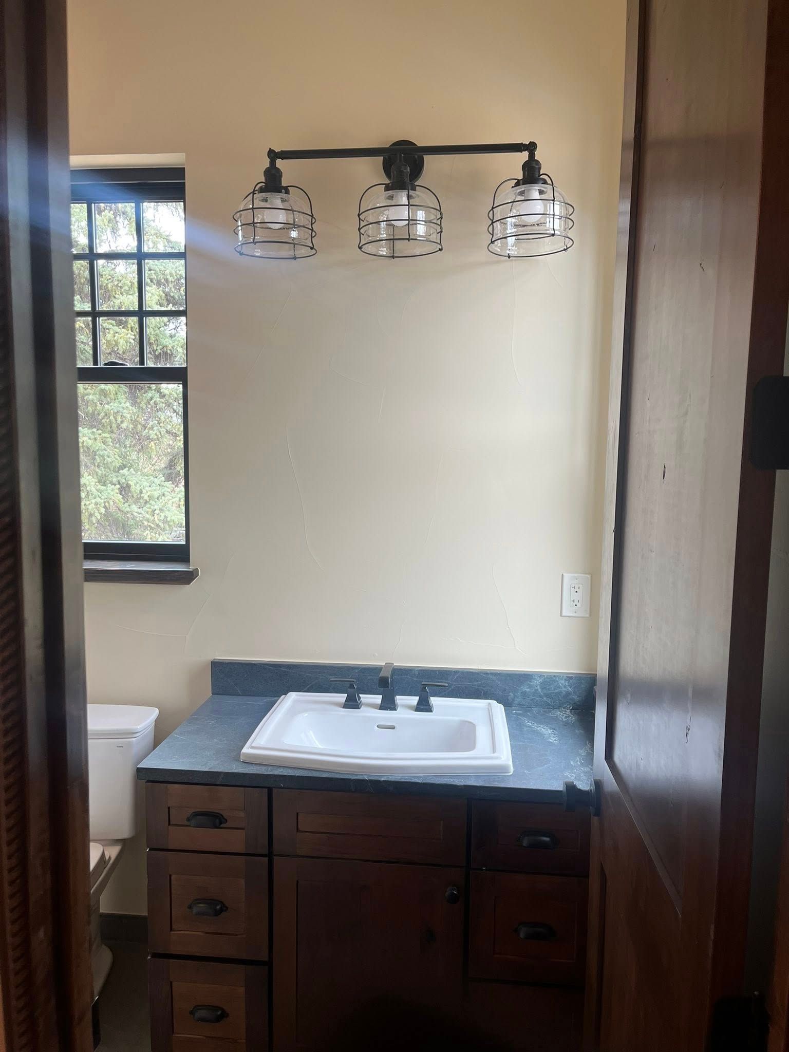 Bathroom with a sink, vanity, window, and overhead light fixture.
